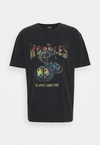 Camiseta de algodón negra con un gráfico colorido de una serpiente y el texto "THE KOORBLES THE VIPERS SUMMER TOUR" en la parte delantera.