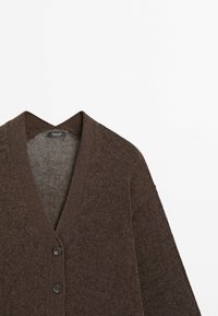 Cardigan tricoté marron à manches longues, col en V, avec deux boutons à l'avant, posé à plat sur un fond blanc.