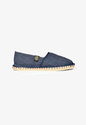 Chaussure style espadrille en denim bleu foncé avec semelle en jute. Présente une pointe ronde et une étiquette logo noire sur le côté. Design simple et décontracté.