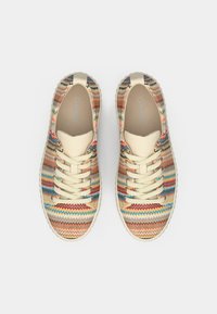 Πολύχρωμα υφασμάτινα αθλητικά παπούτσια με ζιγκ-ζαγκ μοτίβο, κρέμ κορδόνια και υφή σόλας. Ελαφρύς και αθλητικός σχεδιασμός, κατάλληλος για καθημερινή χρήση.