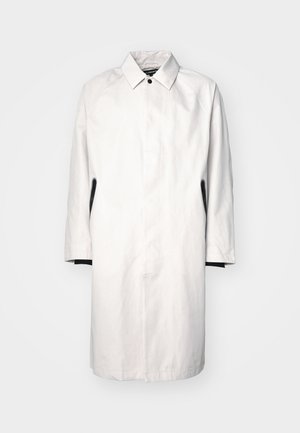 Cappotto grigio chiaro fino al ginocchio con colletto, chiusura a bottoni a pressione e dettagli neri sui lati. Realizzato in tessuto leggero e morbido.