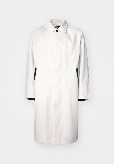 Heleda hallhall, kuni põlve pikkune helesinine mantel, millel on krae, nupuga sulgemine ja mustad aktsendid külgedel. Valmistatud siledast, kergest kangast.