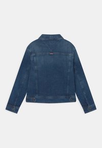 Dark blue denim jacket with long sleeves, point collar, and buttoned cuffs. Features a back yoke with a small color accent and two side buttons.