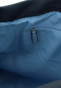 Marine leren tote bag interieur met een gladde, lichtblauwe stofvoering, voorzien van een ritszak en een insteekvak voor organisatie.