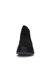 Scarpa nera in suede senza lacci con punta arrotondata, tomaia testurizzata e suola in gomma nera resistente. Presenta cuciture minime e un design snello.