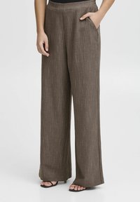 Breda ben, texturerade bruna byxor med en subtil lyster. Har sidofickor och en slät midja, lämpliga för både avslappnad och formell användning.