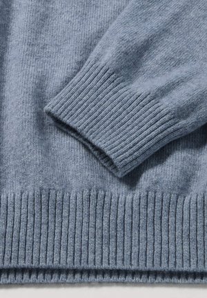 Light blue knitted sweater featuring ribbed cuffs and hem, with a soft texture and smooth finish. Details highlight craftsmanship.