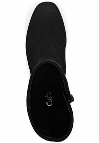 Chukka en suede noir avec un bout-pointu élégant, texture lisse et un détail de boucle sur le côté. L'intérieur présente une doublure noire assortie.