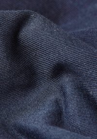 Tmavě modrý materiál s texturovanou tkaninou, který má jemné rýhy a hladký splývavý vzhled, vystavující jemné vlákna a měkký povrch.