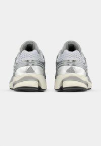Sive i srebrne atletske cipele s mrežastim gornjim dijelom, teksturiranim detaljima, debelim potplatima i oznakom "FORMOTION" na peti.