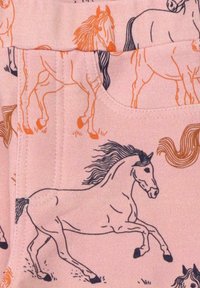 Hellrosa Stoff mit einem wiederholten Muster von schwarzen Umrisspferden mit orangefarbenen Akzenten, die verschiedene Posen und Laufbewegungen zeigen.