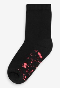 Chaussettes en coton noires avec une texture côtelée, présentant un motif de taches roses au fond. Modèle à cheville avec un embout arrondi.