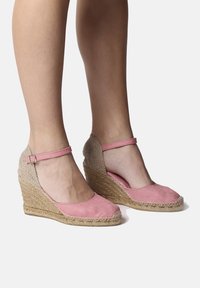 Sandalias de cuña de lona rosa con tacón de yute trenzado, con una correa alrededor del tobillo y puntera redonda.