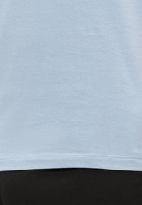Light blue cotton t-shirt with a smooth texture, short sleeves, and a straight hem. No patterns or graphics visible.
