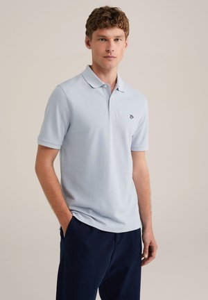 Helles blaues Polohemd aus strukturiertem Stoff, kurzärmlig und mit einem Kragen mit drei Knöpfen. Besitzt ein kleines schwarzes Logo auf der Brust.