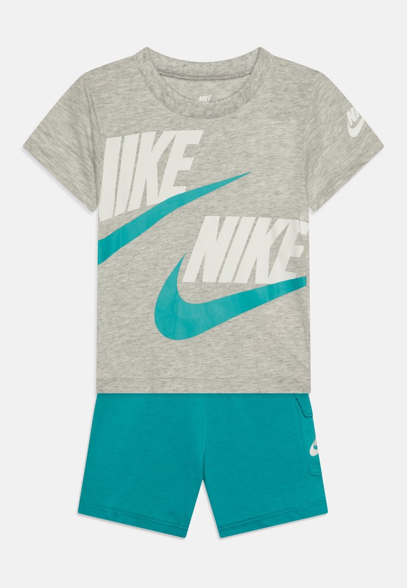 Gray t-shirt with white and turquoise Nike logos, paired with turquoise shorts featuring a side pocket and Nike logo. Made of soft fabric.