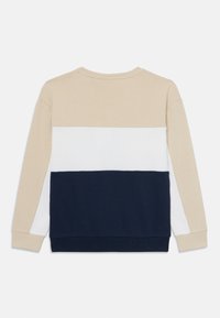Beige, hvit og marineblå fargeblokket genser med ribbestruktur, rund hals og lange ermer. Materiale i bomullsblanding for komfort.