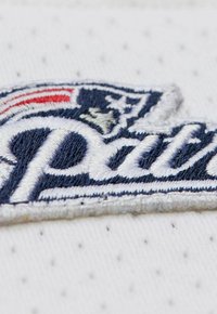 Gesticktes Logo der New England Patriots auf einem weißen Netzstoff mit blauen und roten Akzenten; verfügt über strukturierte Nähte und geschwungene Formen.
