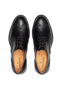 Chaussures habillées en cuir noir avec un design à pointe d'aile, des détails de brogue élaborés et une finition lisse. Doublure intérieure marron avec le nom de la marque visible.