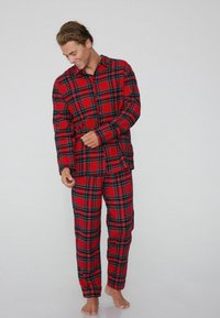 Rot kariertes Schlafanzugset mit einer knöpfbaren Bluse und passenden Hosen, aus weichem Stoff mit einem klassischen Karomuster in Schwarz und Grün.