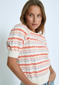 Pullover a righe testurizzate in arancione, lavanda e bianco. Presenta maniche a palloncino e un collo e orlo a coste. Tessuto in maglia morbida.