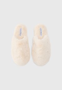 Chinelos bejes felpudos com sola plana, parte traseira aberta e decorados com pequenas aplicações. Textura macia e forma arredondada para maior conforto.