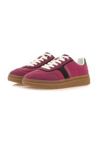 Zapatillas de ante rosa con cordones blancos, panel lateral negro, acento verde en el talón y suela de caucho marrón texturizada. Presenta un diseño de punta redondeada.