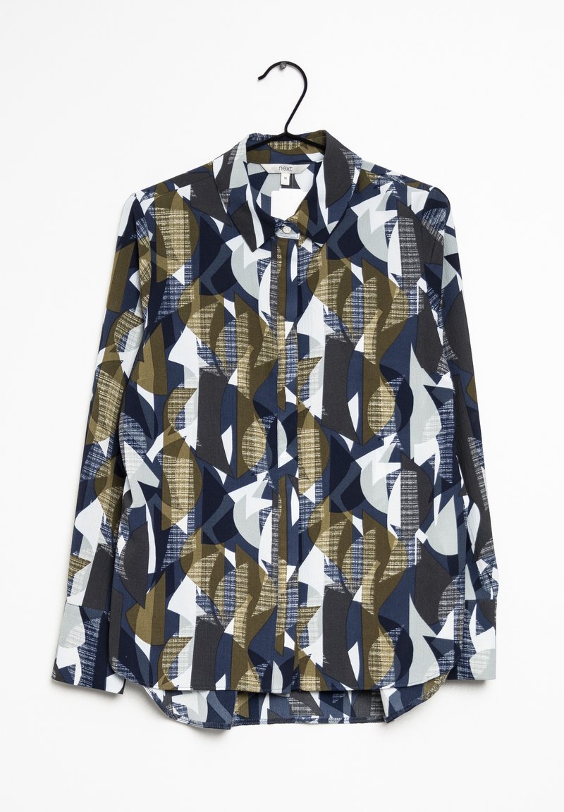 Chemise à manches longues avec col et boutons, présentant un motif géométrique abstrait en bleu marine, olive, gris et blanc, suspendue sur un cintre noir.