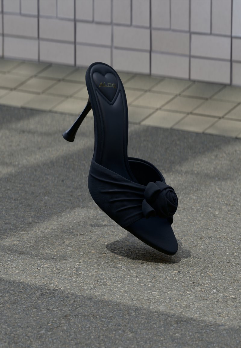 Sandalo aperto con tacco alto nero, caratterizzato da una tomaia in tessuto morbido con dettaglio a nodo a forma di rosa sul davanti e punta appuntita.