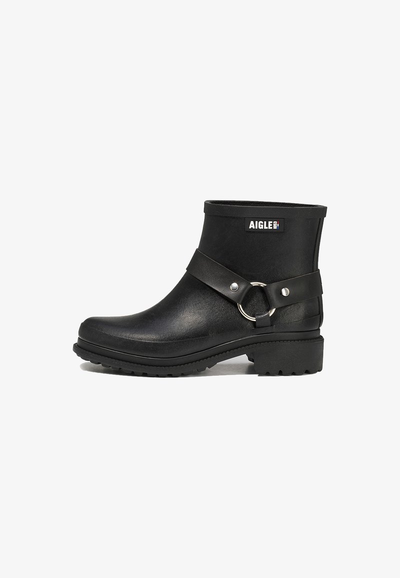 Black ankle boots made of rubber with a textured finish. Features a wide strap with a circular metal ring, durable outsole, and branded logo.