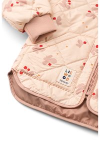 Καπιτονέ, ανοιχτό ροζ μπουφάν με κρέμ επένδυση, που διαθέτει ανθικό σχέδιο σε κόκκινο και πορτοκαλί. Περιλαμβάνει ριμπ μανσέτες και ταμπελάκι με λογότυπο.