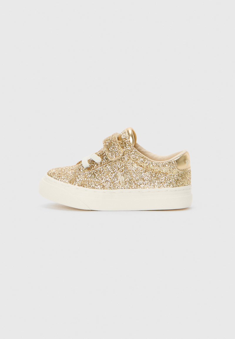 Aukso blizgučiai sportbačiai su balta gumine pakulne, pasižymintys šiurkščiais raišteliais ir paminkštintu apykakle patogumui.