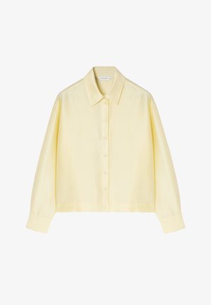 Rumena srajca z dolgimi rokavi, klasičnim ovratnikom, gladko teksturo in sproščenim krojem, z zapenjanjem na šest gumbov spredaj.