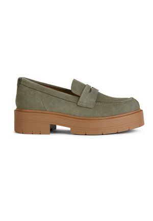 Mocassini verde in suede con suola piatta e spessa marrone e un semplice dettaglio a fascia sulla parte anteriore. Texture liscia con evidenti cuciture.