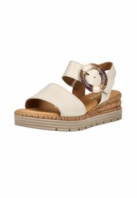 Sandalia beige de punta abierta con una ancha correa frontal, correa en el tobillo con hebilla redonda grande tejida y suela con plataforma de textura de corcho con fondo acanalado.