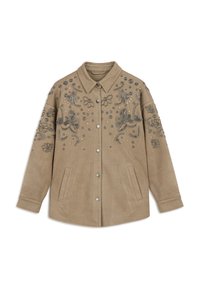 Beige suède jack met een knoopsluiting aan de voorkant, versierd met zilverkleurige bloemenborduursels en ingewikkeld paillettenwerk. Heeft zijzakken.