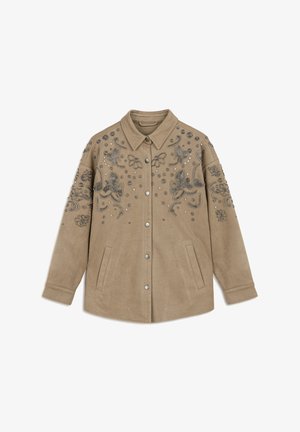 Veste en daim beige avec un devant à boutons, décorée de broderies florales en tonalités argentées et d'un travail de perles complexe. Dotée de poches latérales.