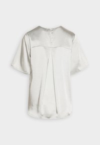 Blouse à manches courtes en satin argenté clair, avec un col rond, un pli plat au dos et une fermeture à bouton unique au niveau du col.