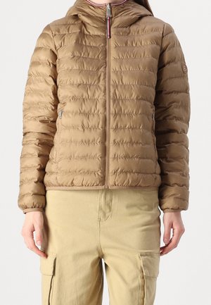 Woman wearing a light brown quilted zip-up jacket with hood and beige cargo pants, standing against a plain background.