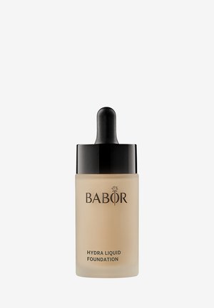Flacon compte-gouttes de BABOR Hydra Liquid Foundation avec un liquide beige et un bouchon noir sur fond blanc.