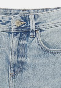 Jeans in denim blu chiaro con un design sbiadito, presentano una chiusura con bottone, stile a cinque tasche e cuciture beige lungo le cuciture.