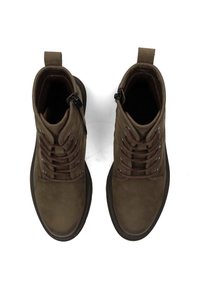 Bottines en suède marron avec un système de laçage à plusieurs œillets, fermeture à glissière sur le côté et une semelle en caoutchouc texturée. Dispose d'une languette au talon.