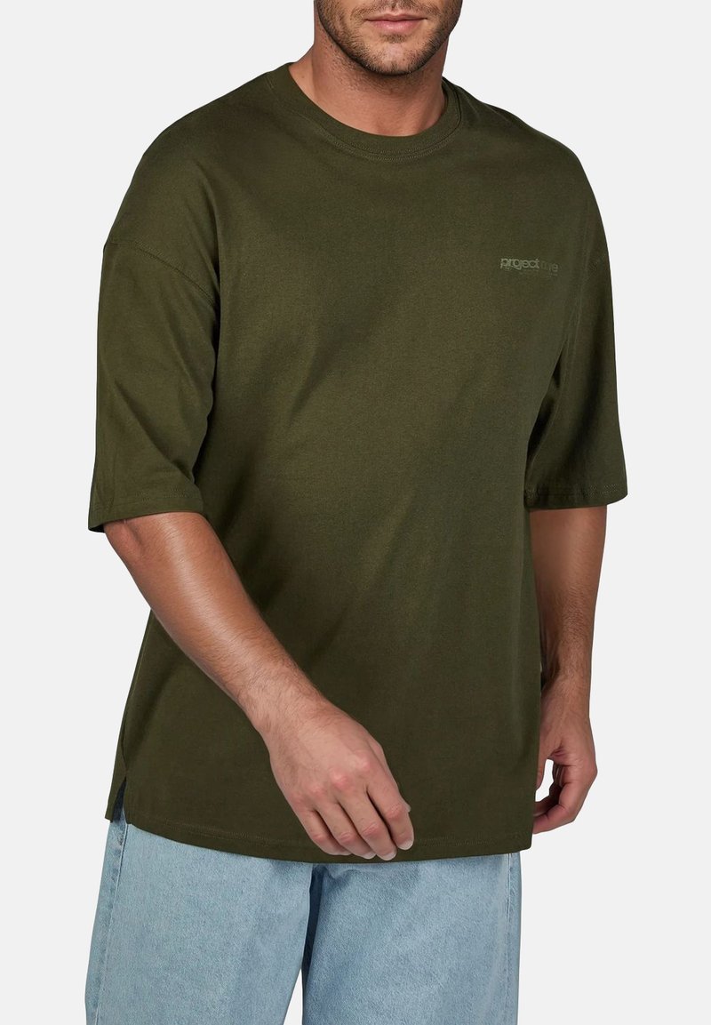 Olijfgroene oversized t-shirt van katoen. Heeft een ronde hals en korte mouwen, met een subtiele logo op de voorkant.