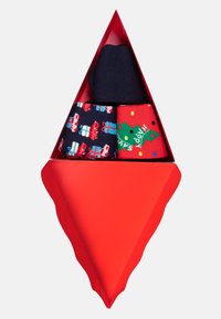 Červená trojúhelníková krabička obsahující tři páry ponožek: jedny jednobarevné námořnické, jedny s vánočním designem Santa a dárků a jedny s vánočním stromečkem a tečkami.