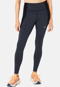 Legginsy z wysokim stanem w kolorze granatowym z czarnymi akcentami. Charakteryzują si�ę gładką teksturą, pionowym wzorem w paski oraz detalem z logo po boku.