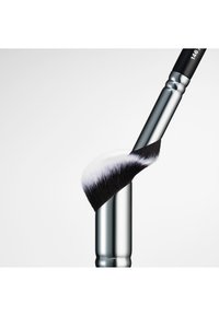 Make-up penseel met een chroom handvat en een schuine witte en zwarte borstelkop, met een zachte, dichte textuur en gladde, gepolijste afwerking.