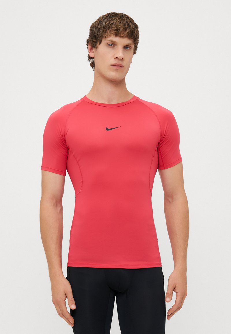 Rdeča športna majica s kratkimi rokavi, izdelana iz raztegljivega materiala, z črnim logotipom Nike na sprednji strani. Prilagojena zasnova in gladka tekstura.
