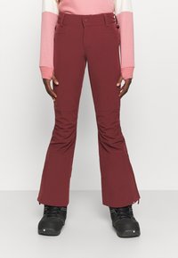 Bordowe spodnie narciarskie z szerokimi nogawkami, z zapięciem na guzik i kieszeniami z przodu. Wykonane z trwałego materiału, zaprojektowane do noszenia zimą.