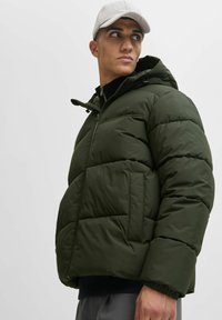 Olivgrüne Pufferjacke mit Kapuze, Reißverschluss vorne und elastischen Bündchen. Verfügt über eine glatte Textur und zwei seitliche Taschen.