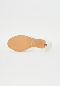 Sandalia de tacón blanca con tiras transparentes, parte superior lisa y suela de goma texturizada color marrón. Etiqueta "BIANCO" en la plantilla. Diseño de punta redondeada.